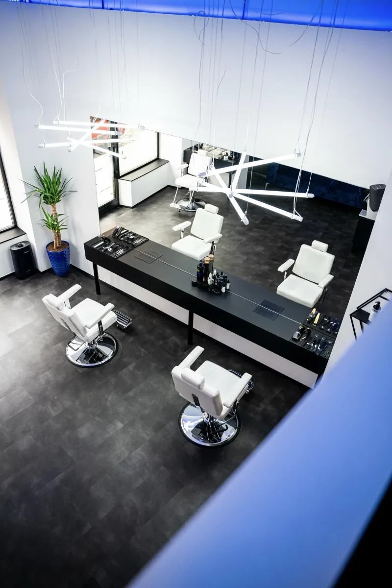 Designový a minimalistický interiér Next Barber Shopu v Plzni – pohled shora na pracovní místa