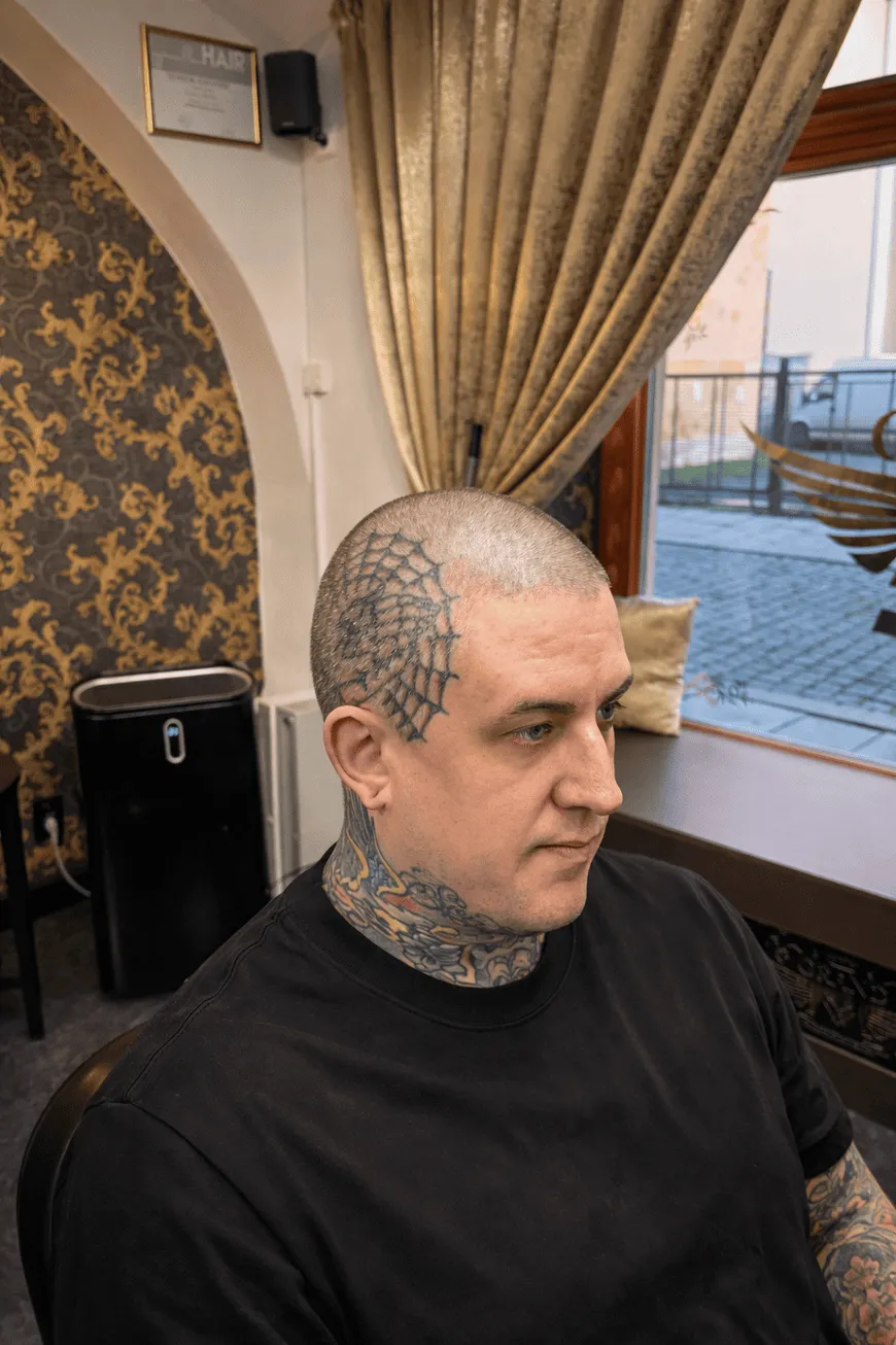 Pánský účes skin fade u klienta s tetováním v prestižním Grand Barber Shopu