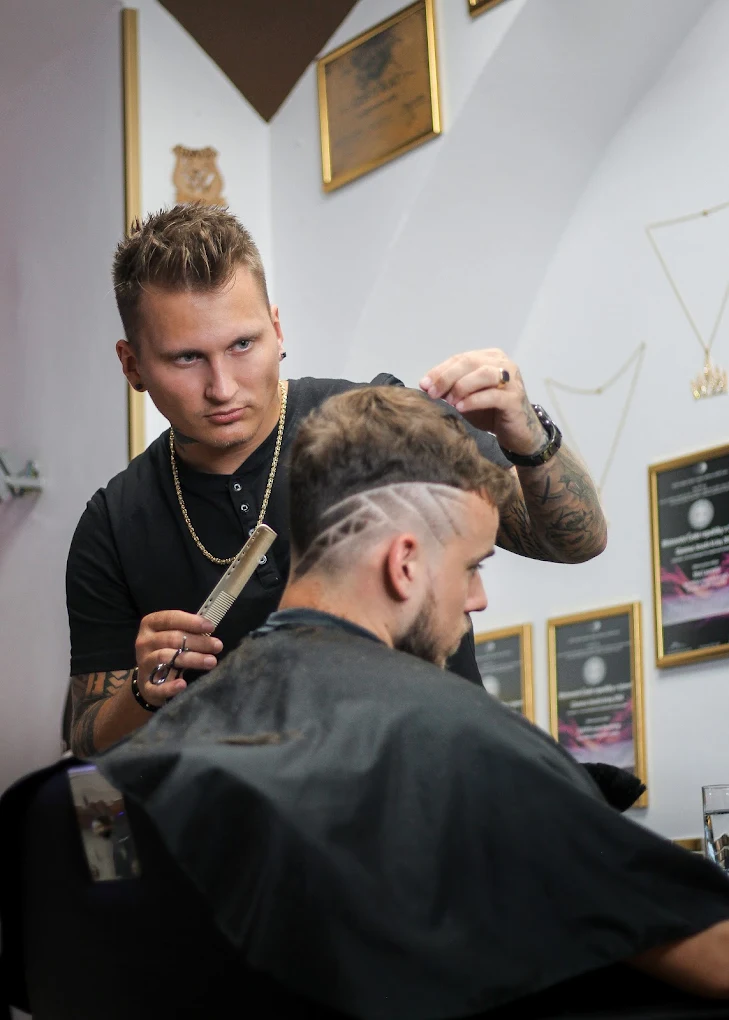 Barber při precizním střihu v Grand Barber Shop