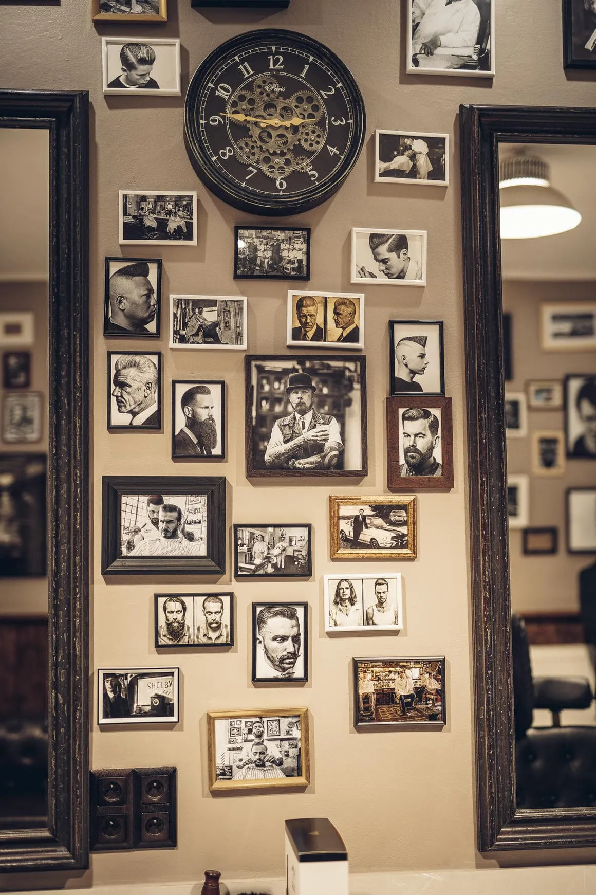 Stylová stěna s vintage fotografiemi a obrazy v tradičním Shelby Barber Shop Plzeň